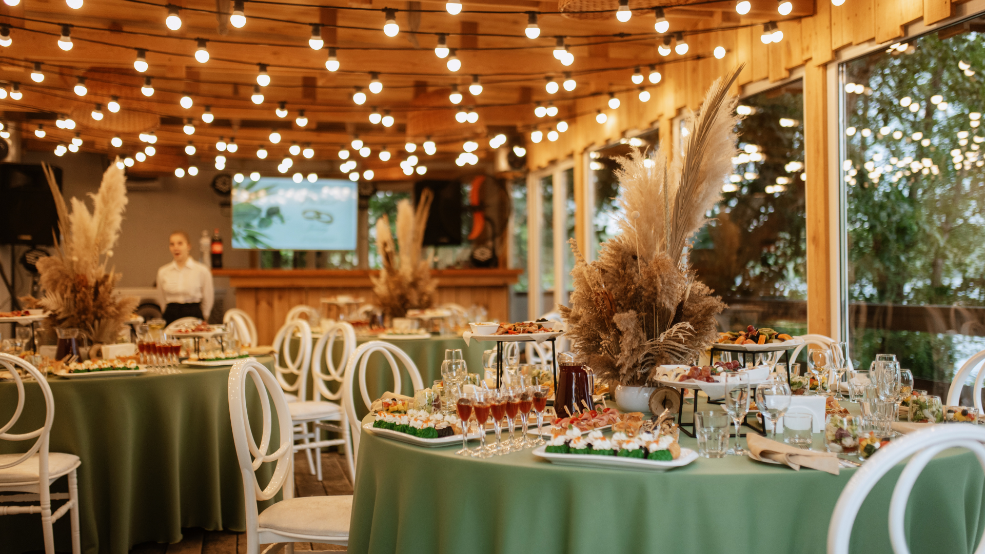 A large room with tables and chairs set up for a wedding reception.