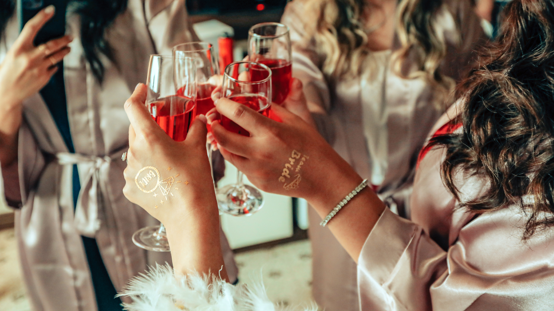 A group of women are toasting with champagne glasses at a bachelorette party.