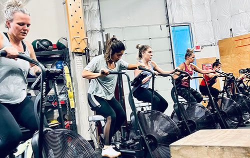 A group of women are riding exercise bikes in a gym.