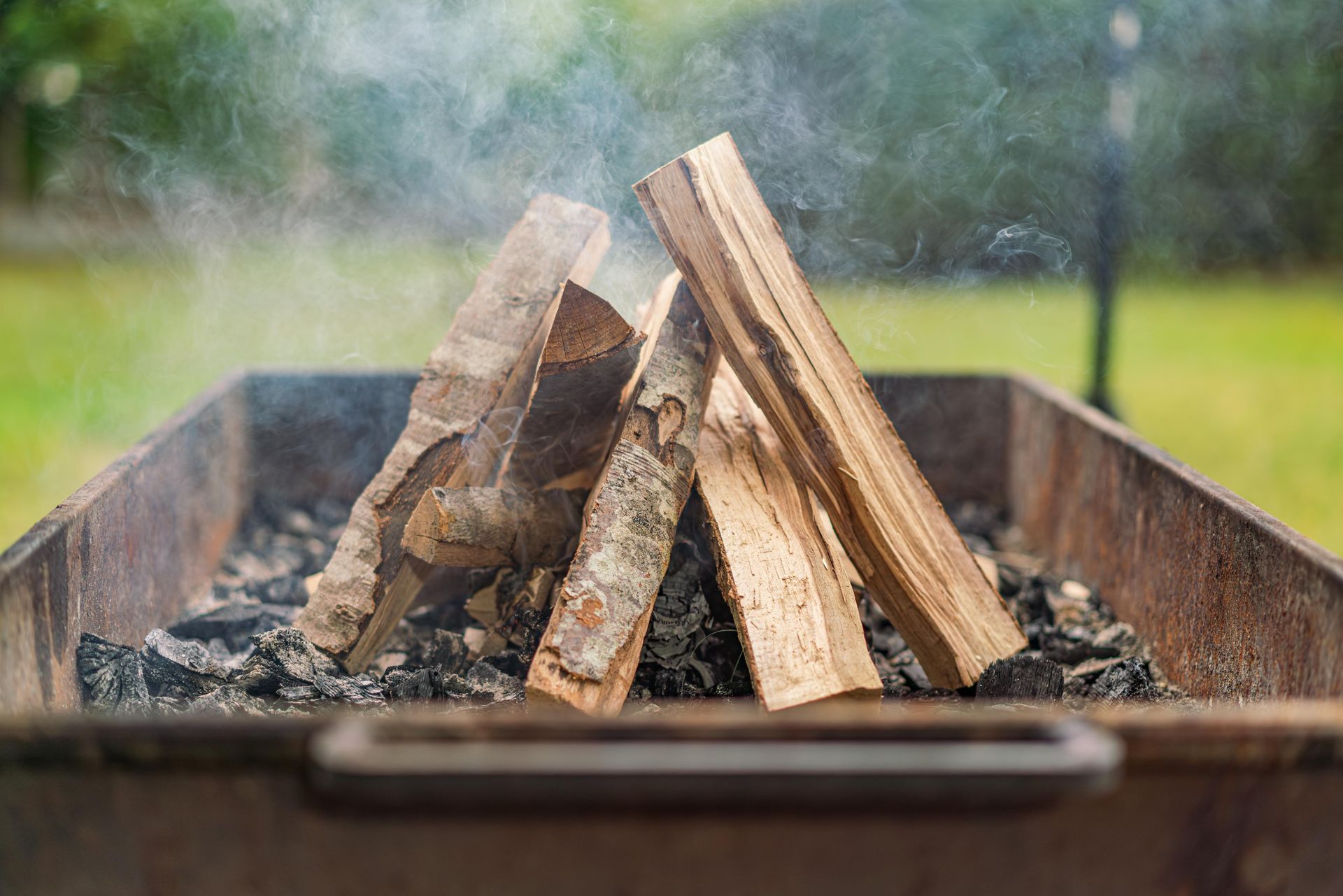 A pile of wood is sitting on top of a grill.