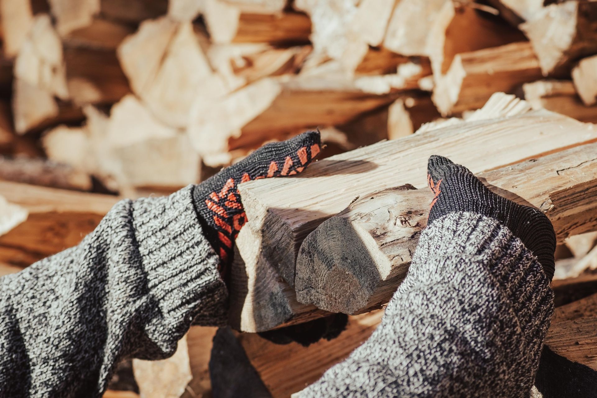 A person wearing gloves is cutting a piece of wood.