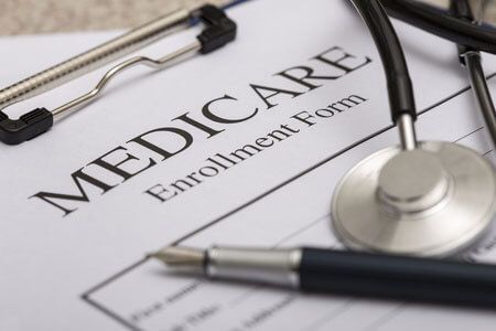 A stethoscope is sitting on top of a medicare enrollment form.
