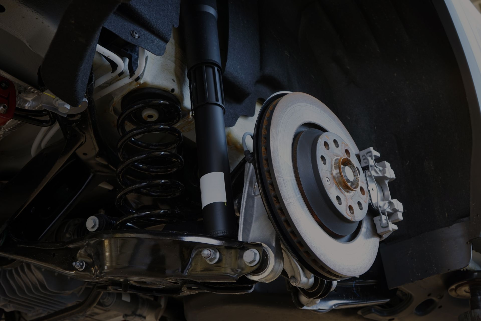 Car suspension and brake system components, including a brake rotor, shock absorber, and spring. | Integrated Automotive