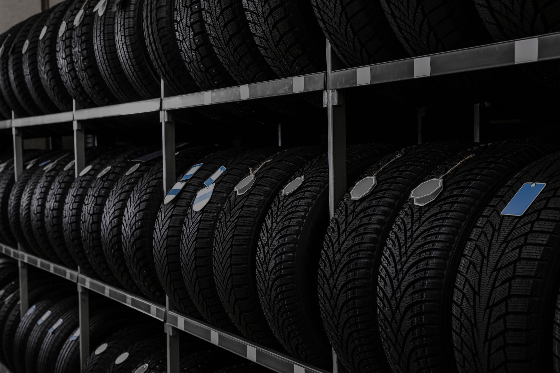 Tires stacked on shelves in a garage, ready for sale. | Integrated Automotive