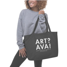A person carries a dark gray tote bag with white text reading 