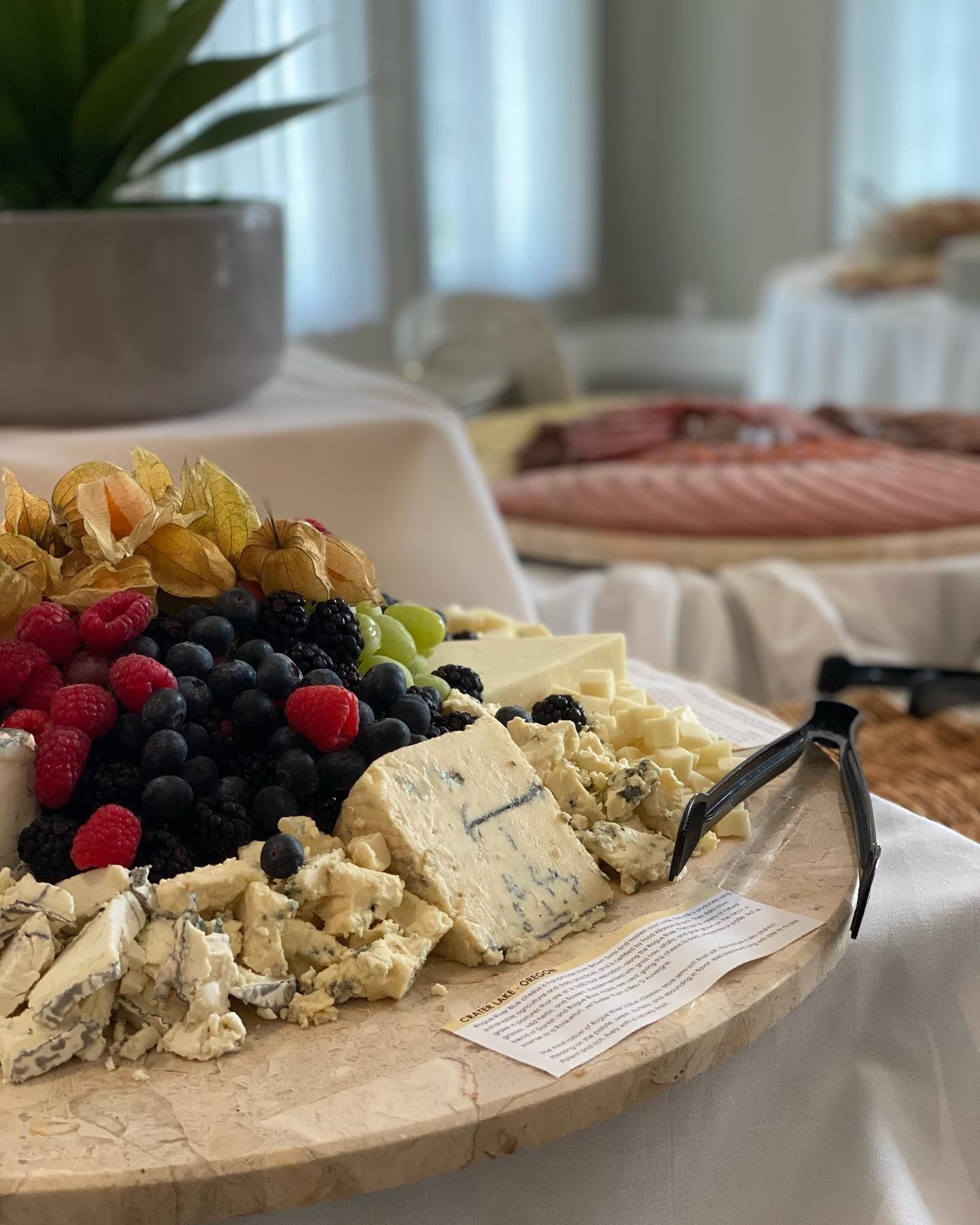 A wooden cutting board filled with cheese and fruit on a table. | Brookeville, MD | Silo Falls