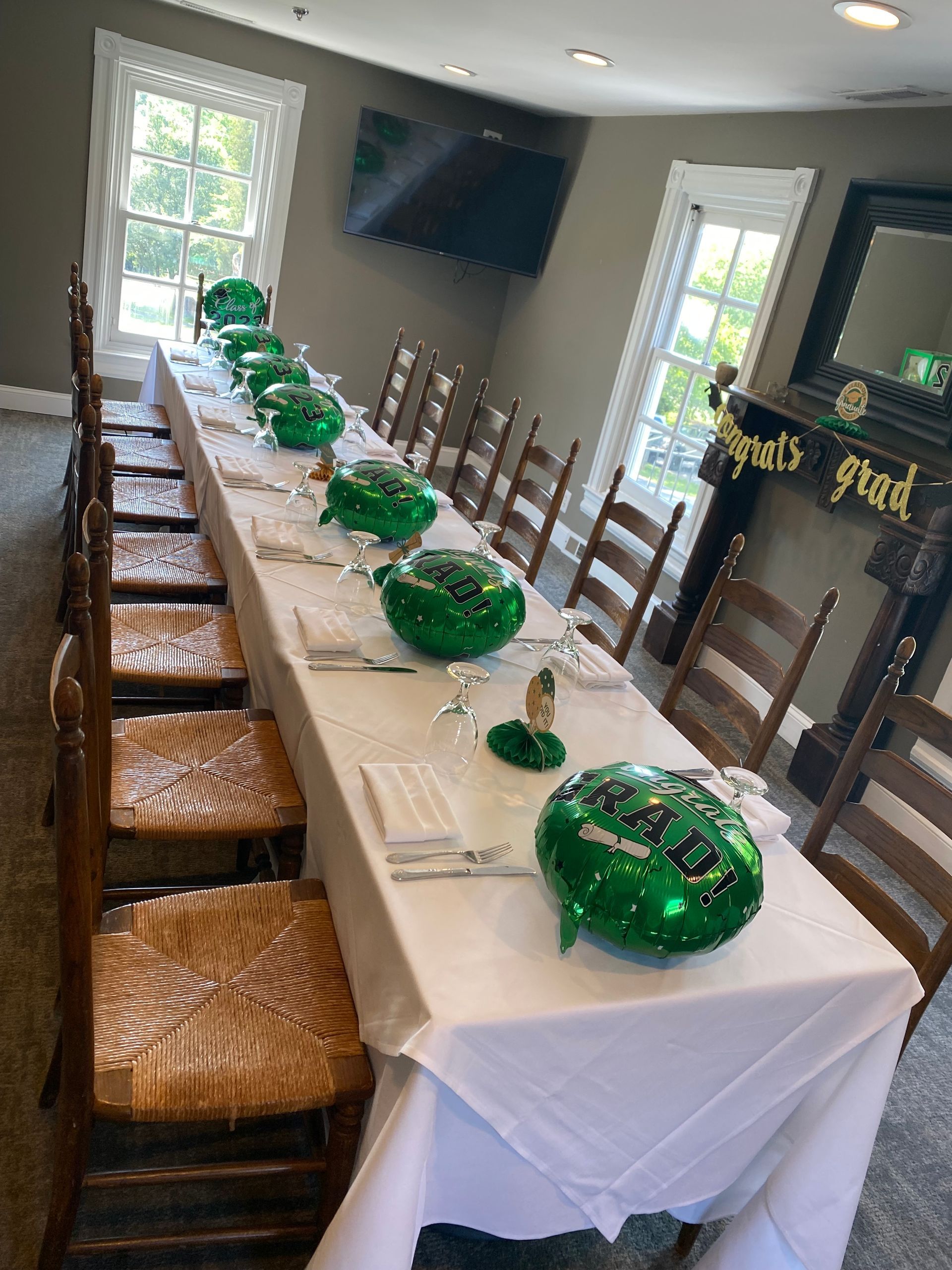 A long table with green balloons on it in a room with chairs. | Brookeville, MD | Silo Falls