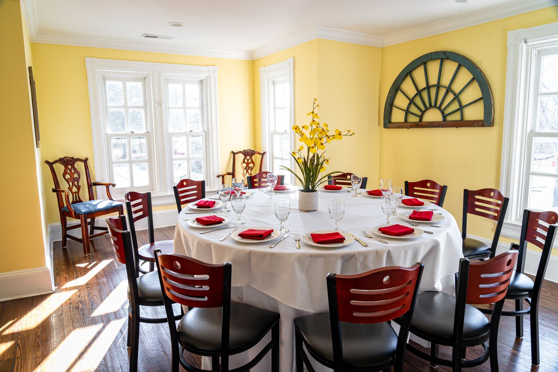 A large dining room with a round table and chairs. v