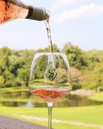 A bottle of wine is being poured into a wine glass. | Brookeville, MD | Silo Falls