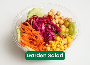 Garden salad bowl with cucumber, carrots, cabbage, corn, olives, and chickpeas.