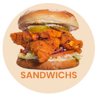 Fried chicken sandwich with pickles, sauce, and lettuce on a bun. 