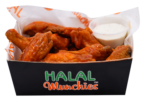 Halal chicken wings in a black tray with dipping sauce, on printed paper.
