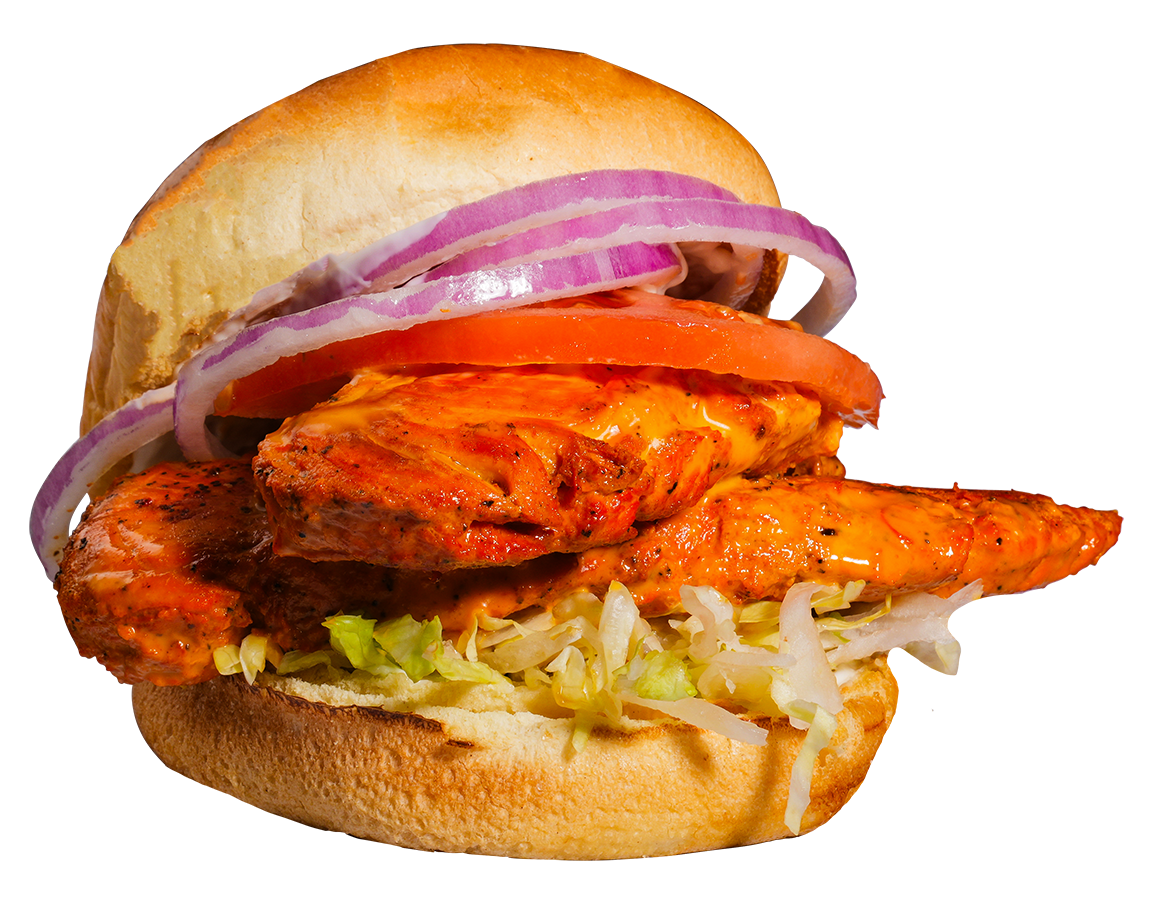 Chicken sandwich with red onion and tomato on a bun.