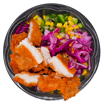 Chicken and veggie salad in a clear bowl; chicken pieces, red cabbage, corn, green peppers.