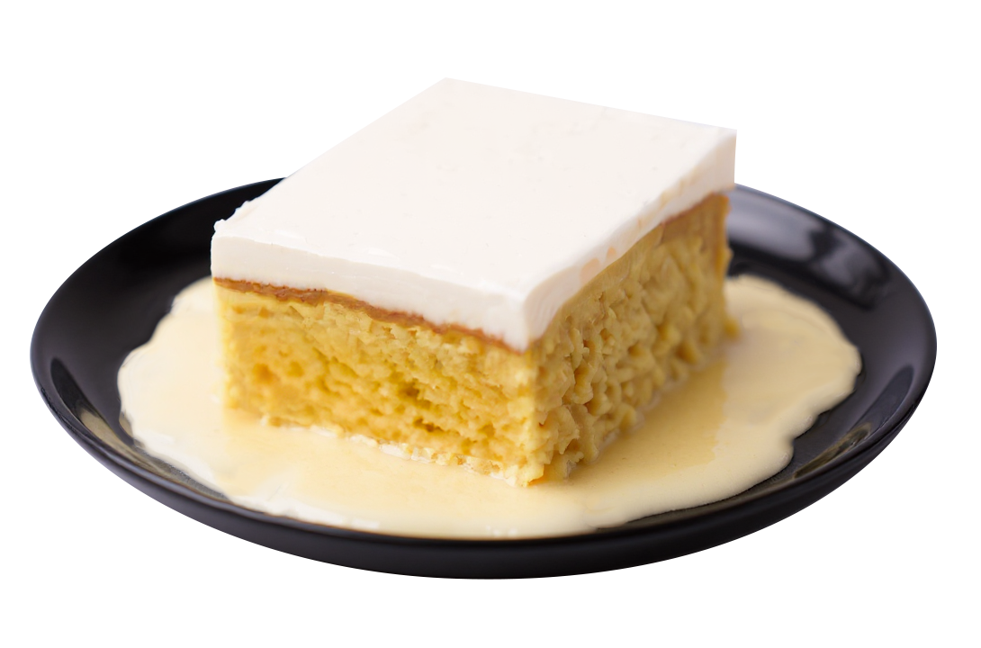 A slice of yellow cake with white frosting sits in a pool of cream sauce on a black plate.