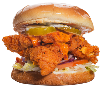 Fried chicken sandwich with pickles, sauce, and vegetables on a bun.