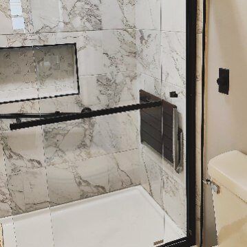 A bathroom with a walk in shower and a toilet.