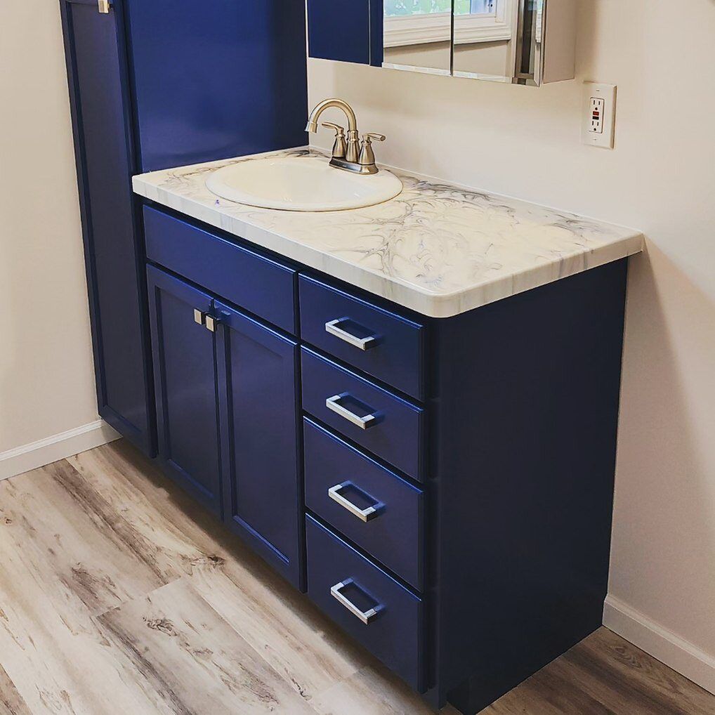 A bathroom with blue cabinets and a sink
