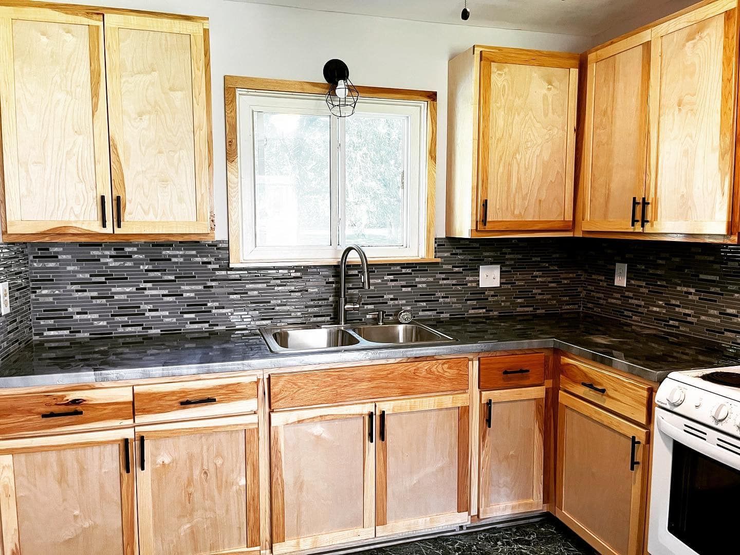 A kitchen with wooden cabinets , a sink , and a stove.
