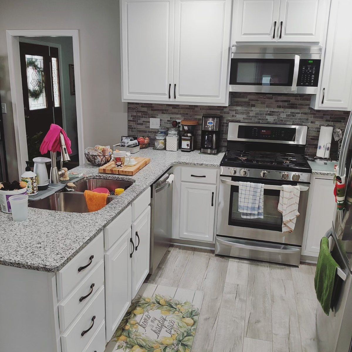 A kitchen with white cabinets and stainless steel appliances