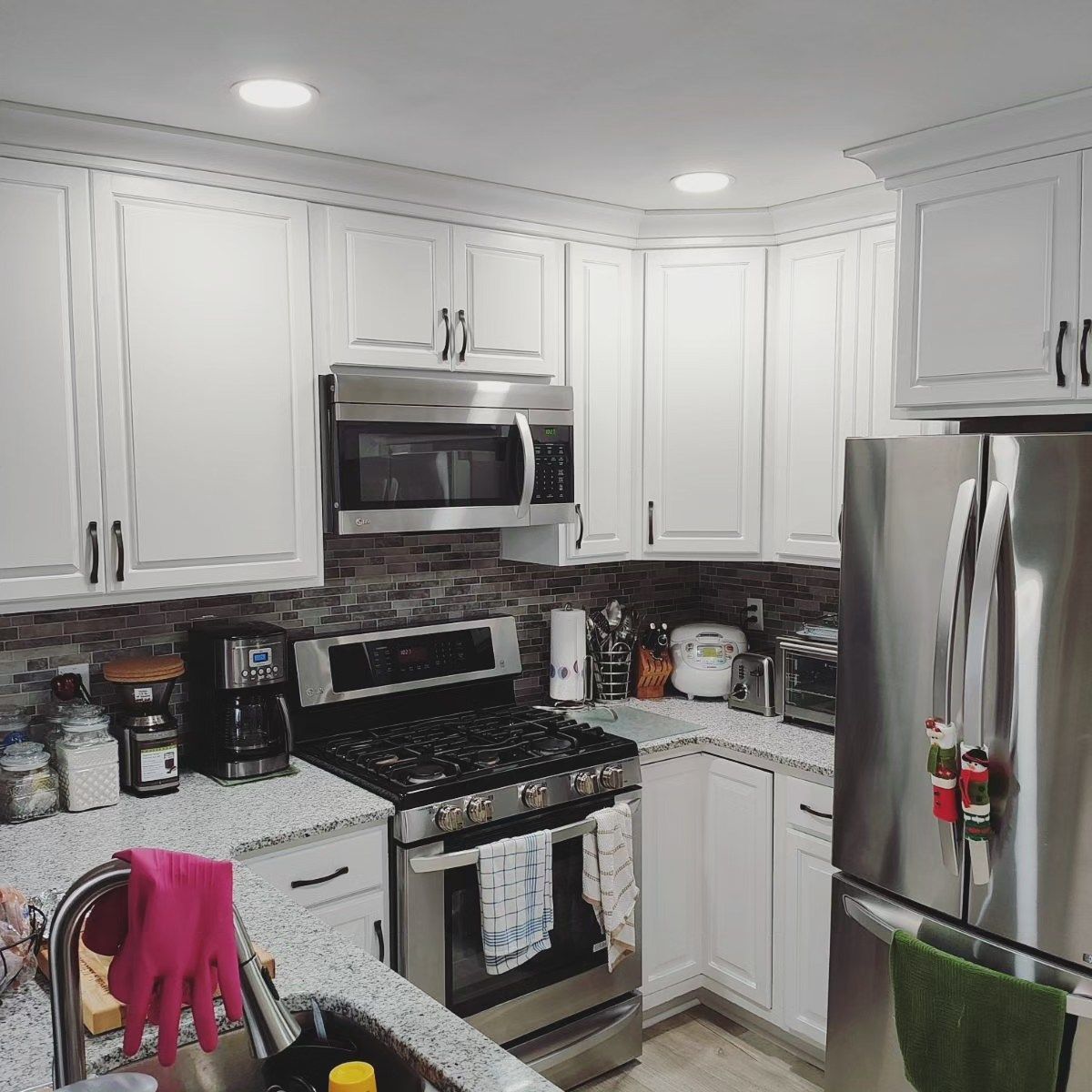 A kitchen with stainless steel appliances and white cabinets