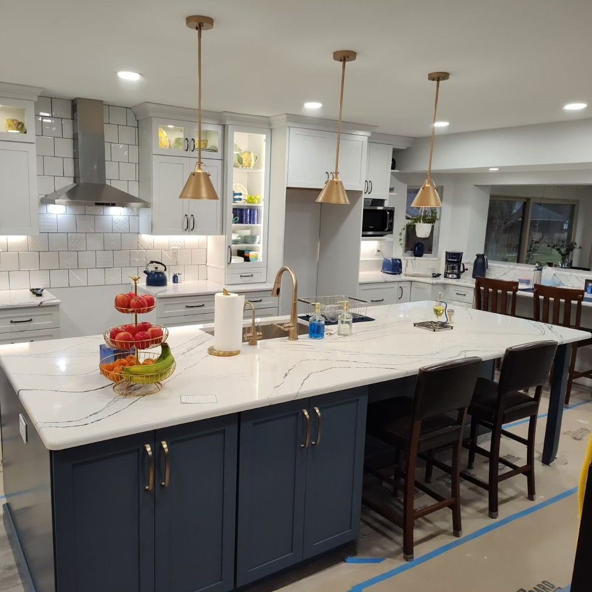 A kitchen with blue cabinets and white counter tops