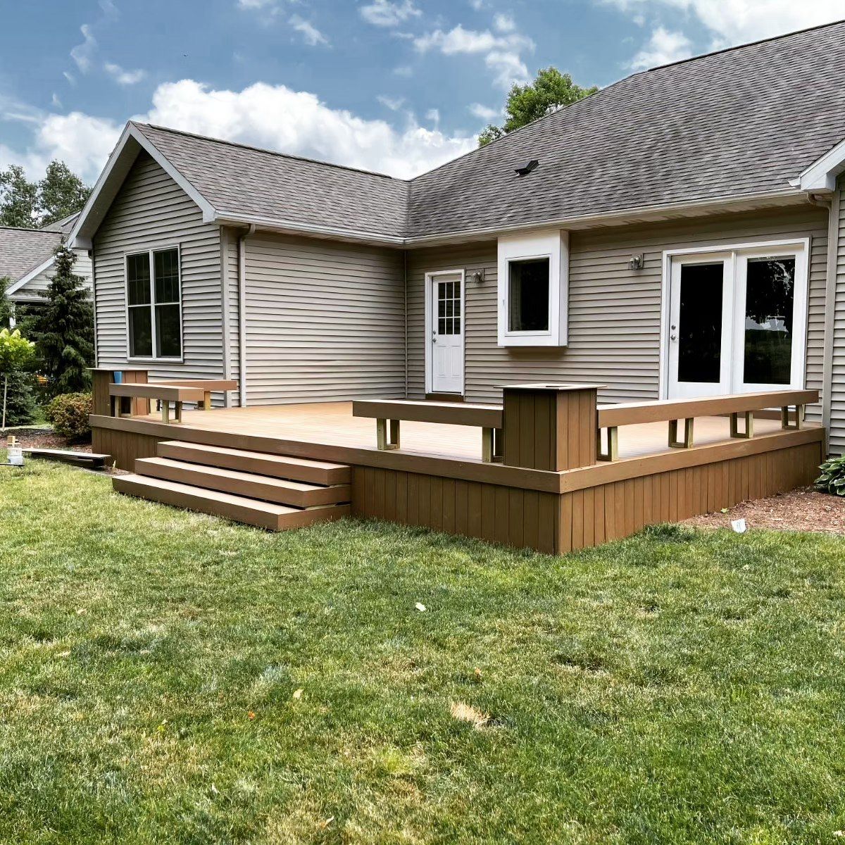 A house with a large deck in the backyard.