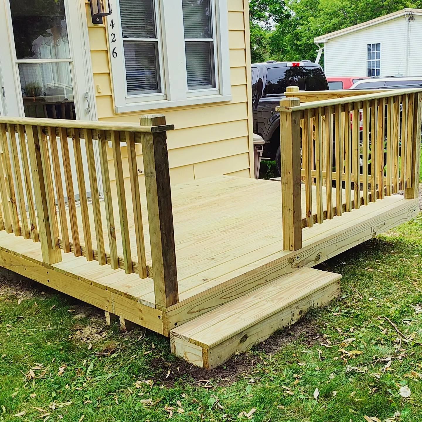 A small house with a wooden deck in front of it