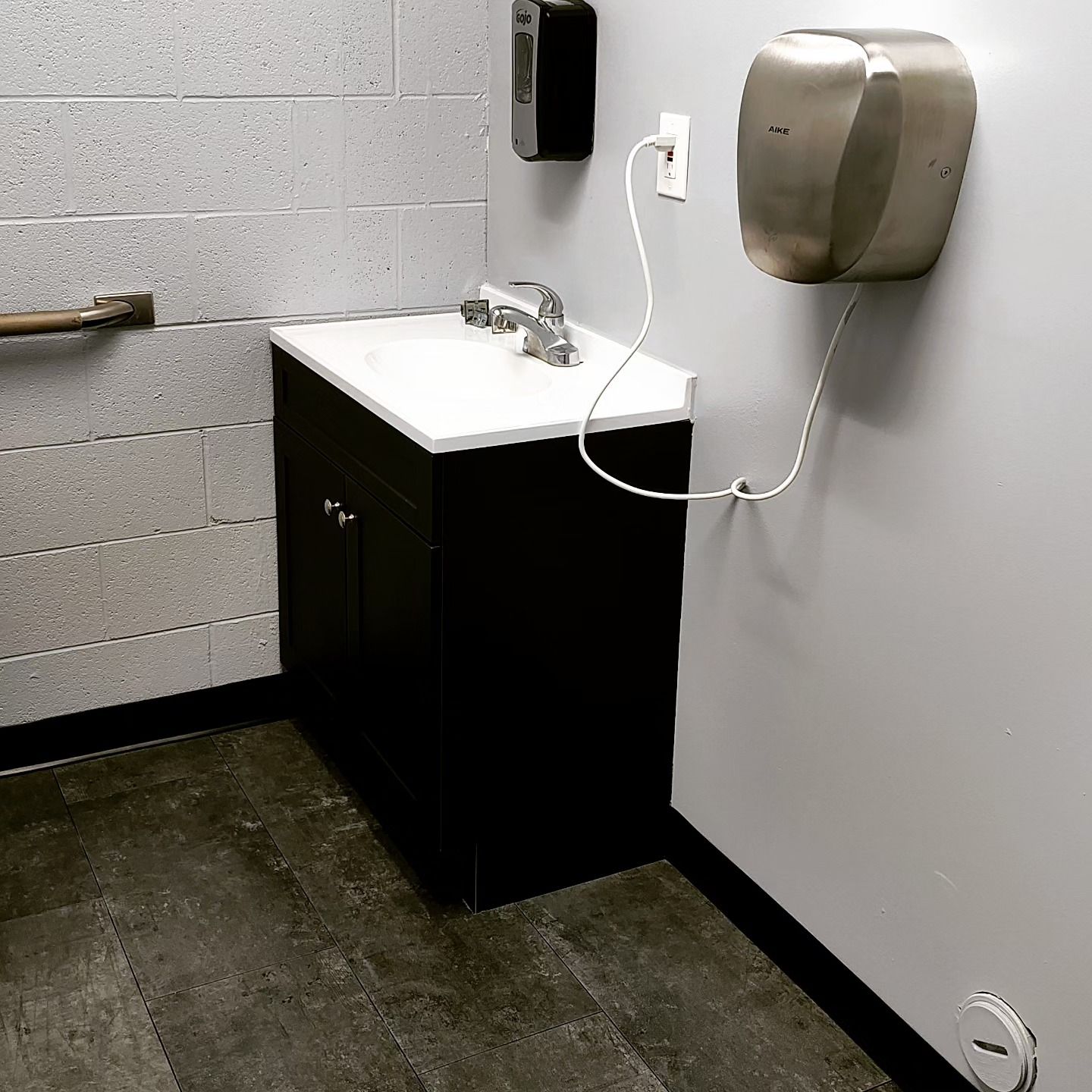 A bathroom with a sink and a hand dryer