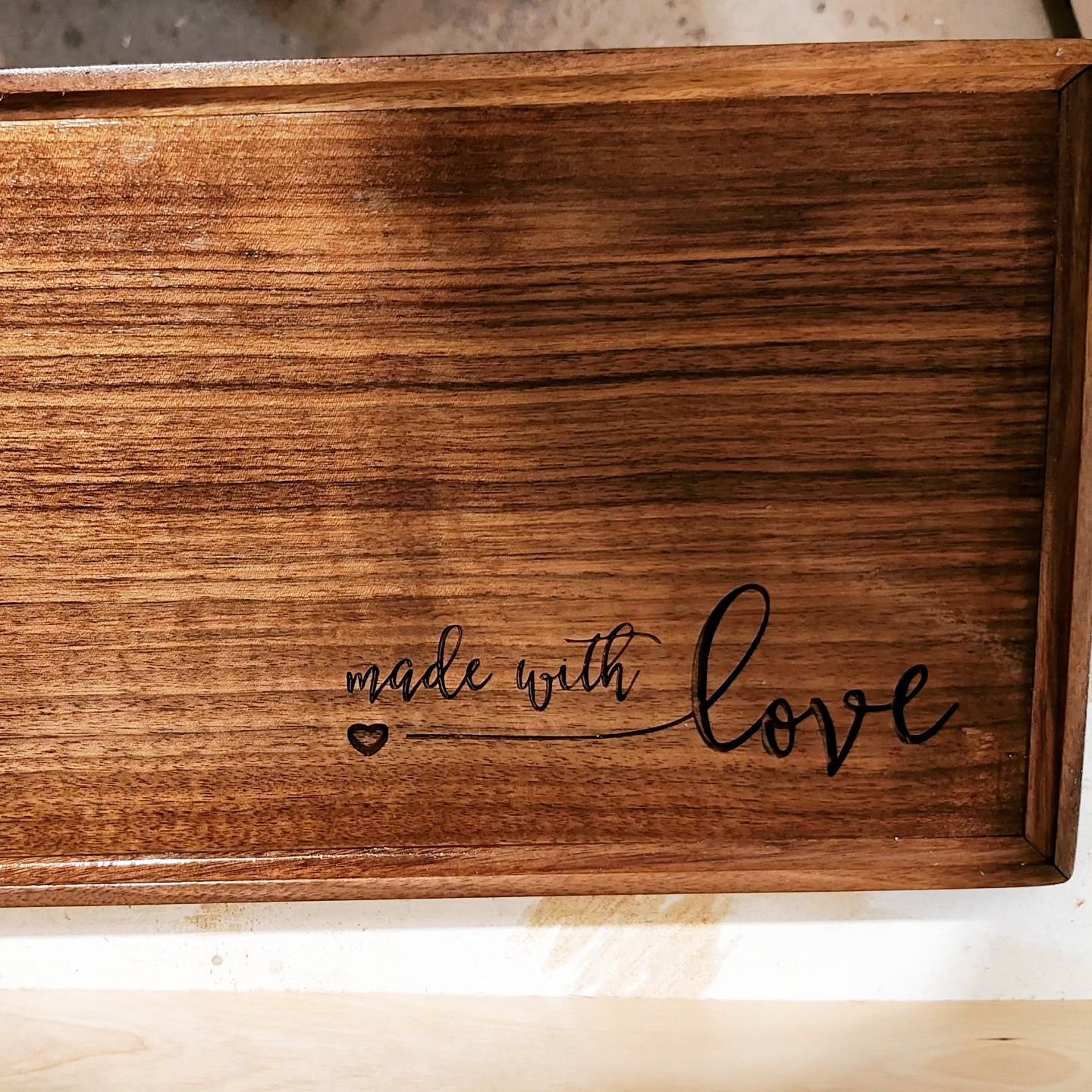 A wooden tray with the words `` made with love '' engraved on it.
