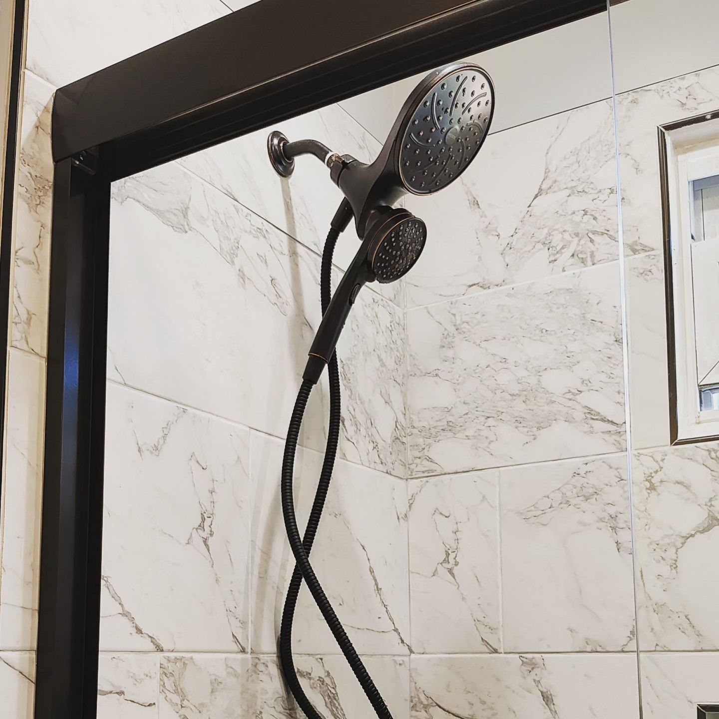 A close up of a shower head in a bathroom