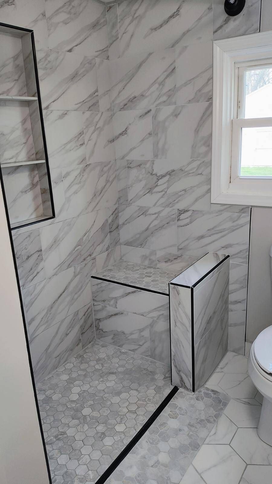 A bathroom with a walk in shower and a toilet.