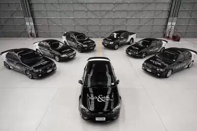 A group of black cars are lined up in a garage.