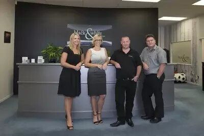 A group of people are standing in front of a counter in an office.