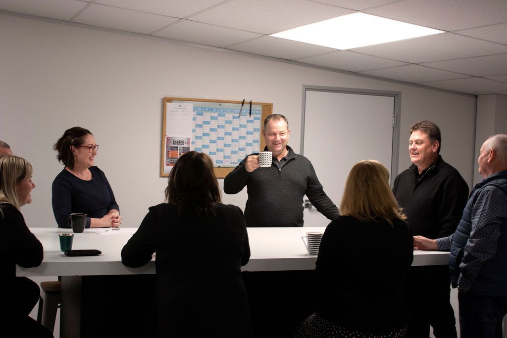 A group of people are sitting around a table in a room.