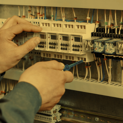 A person is working on a circuit board with a screwdriver
