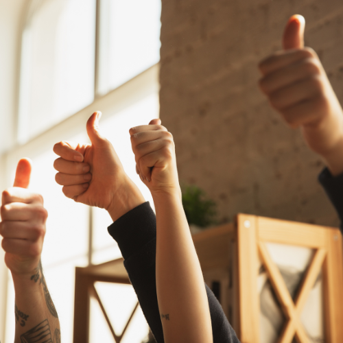 A group of people are giving a thumbs up
