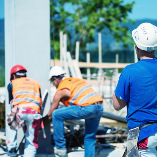 A group of construction workers wearing hard hats and vests