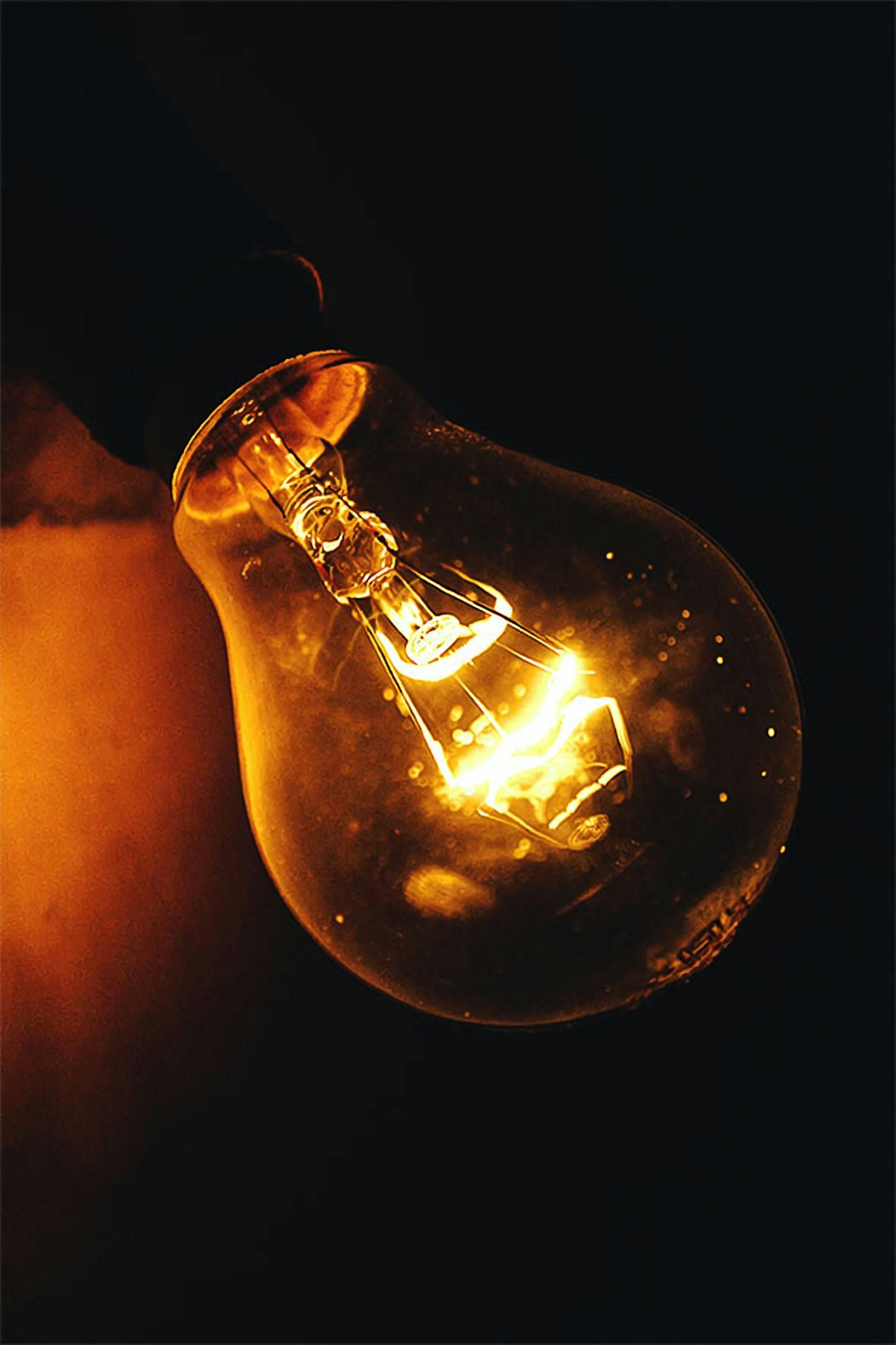 A close up of a light bulb glowing in the dark.