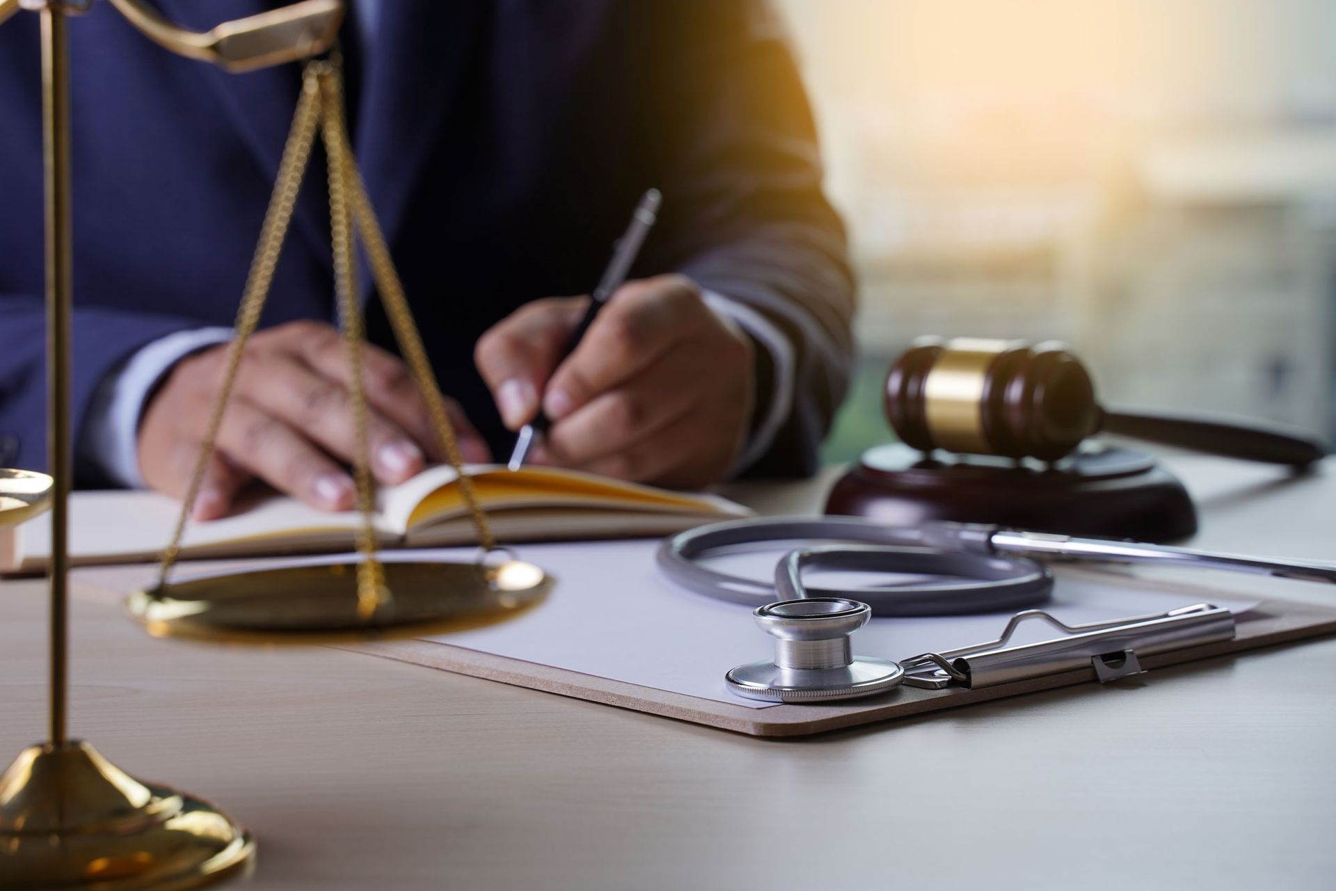 Law scale, gavel, and stethoscope in a desk. Health care business concept
