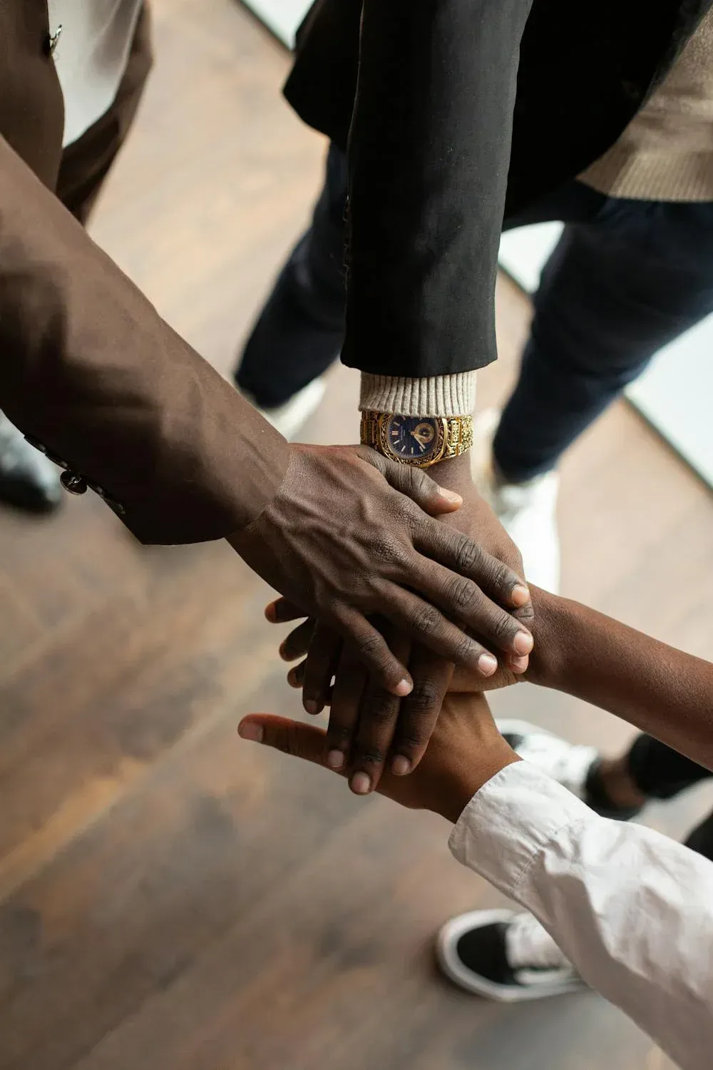 A group of people are putting their hands together.