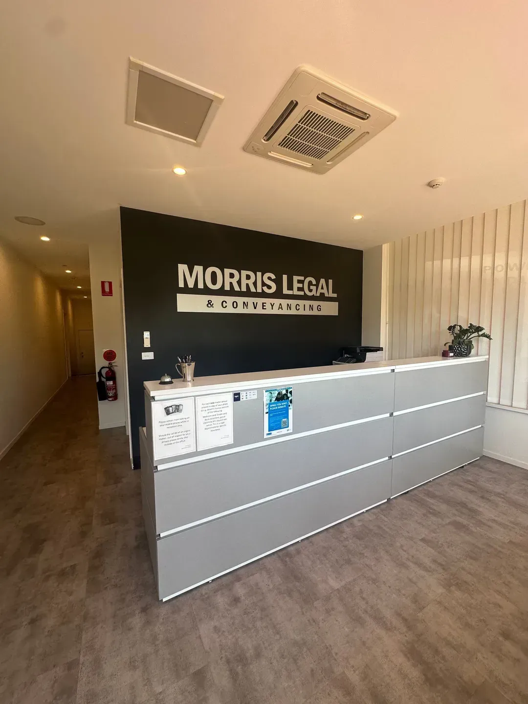 A Reception Desk With Morris Legal & Conveyancing Sign on a Wall — Morris Legal & Conveyancing in Forster, NSW