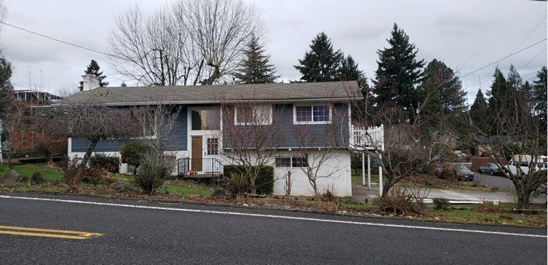 A house is sitting on the side of the road next to a road.