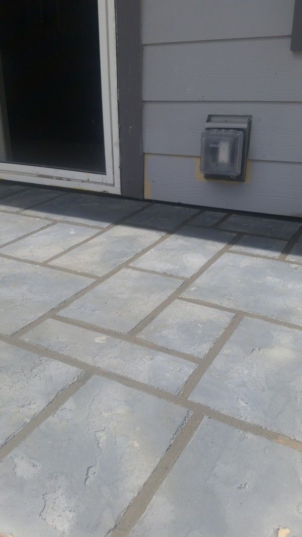 A patio with a light on the side of a house.