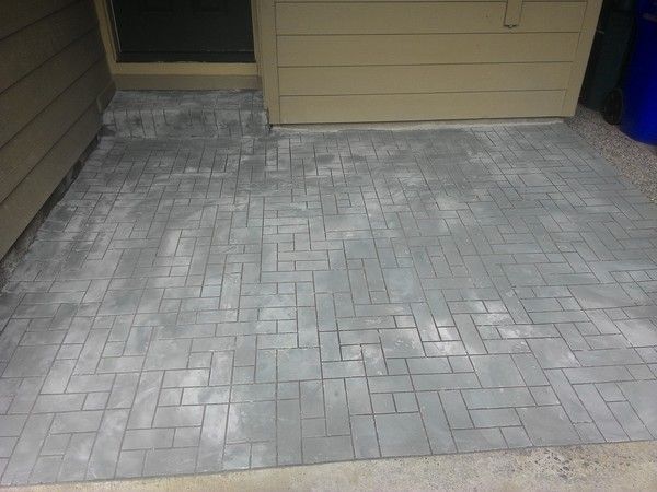 A brick walkway is being built in front of a house.