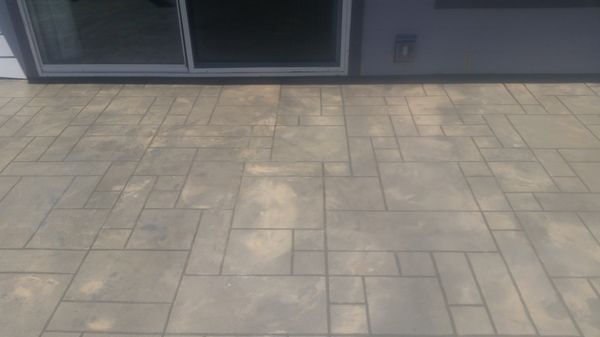 A patio with a sliding glass door and a tiled floor.