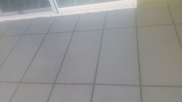 A white tiled floor with a sliding glass door in the background.