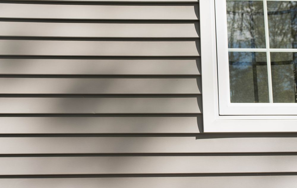 A close up of a house with siding and a window.