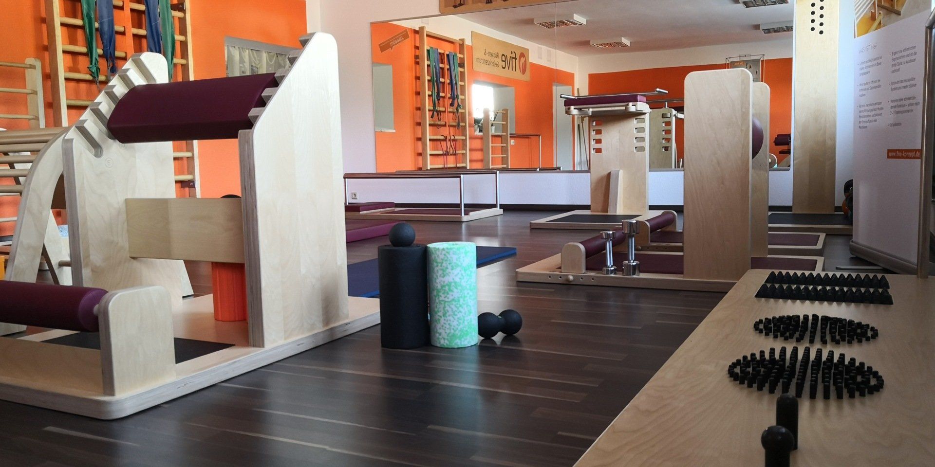 Ein Fitnessstudio mit vielen Trainingsgeräten auf dem Boden