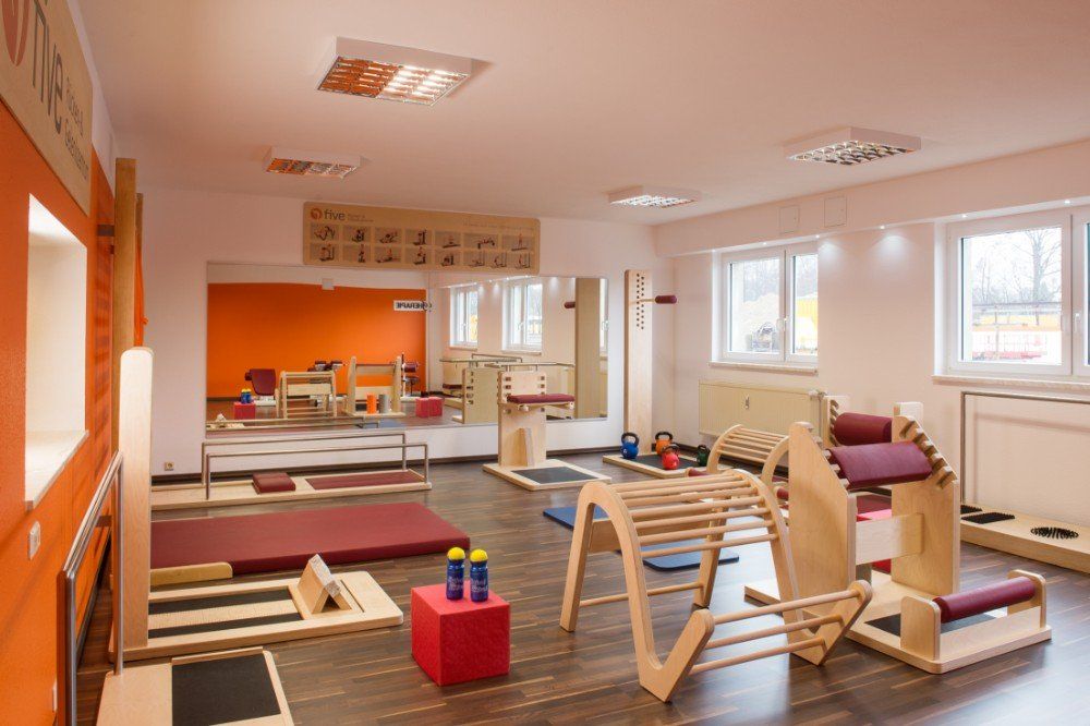 Ein großer Raum mit vielen Trainingsgeräten und einem Spiegel.